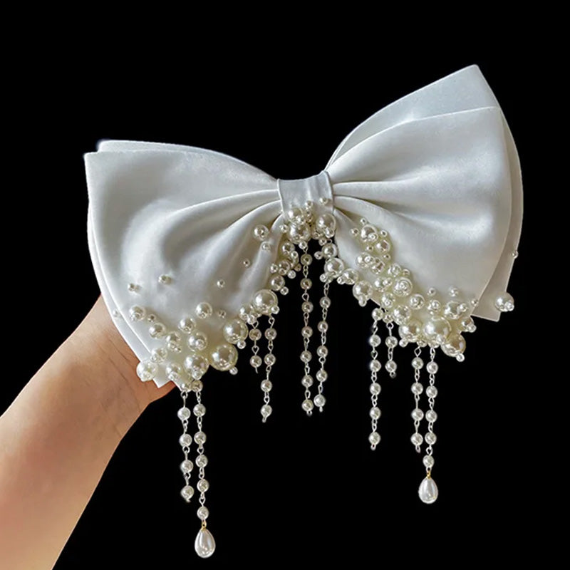 white satin bow with pearls along bottom
